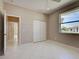 This bedroom includes tile flooring, a ceiling fan, light colored walls, an exterior window, and closet space at 1136 Deardon Dr, Venice, FL 34292