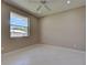 This bedroom includes tile flooring, a ceiling fan, light colored walls, and an exterior window view at 1136 Deardon Dr, Venice, FL 34292