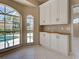 Breakfast nook with transom windows overlooking the pool with custom white cabinetry at 1136 Deardon Dr, Venice, FL 34292