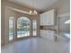 Breakfast nook features windows that overlook the pool with custom white cabinetry and tile flooring at 1136 Deardon Dr, Venice, FL 34292
