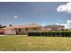 Backyard view of the single-story home featuring a screened-in pool enclosure and privacy hedge at 1136 Deardon Dr, Venice, FL 34292