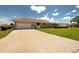 A single-story home featuring a red tile roof and a concrete driveway, surrounded by a green lawn at 1136 Deardon Dr, Venice, FL 34292