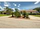 A single-story home with desert-style landscaping and a red tile roof under a blue sky with white clouds at 1136 Deardon Dr, Venice, FL 34292