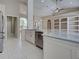 Well-lit kitchen with marble countertops, stainless steel dishwasher, and tile flooring, adjacent to the dining area at 1136 Deardon Dr, Venice, FL 34292