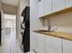Laundry room with updated washer and dryer, built in cabinets, and tile flooring at 1136 Deardon Dr, Venice, FL 34292