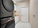 The laundry room has a modern washer dryer set, custom cabinetry, and tile flooring at 1136 Deardon Dr, Venice, FL 34292