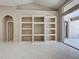 Spacious living room featuring tile floors, built-in shelving, and sliding door access to the outdoors at 1136 Deardon Dr, Venice, FL 34292