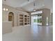 Open living area with tile flooring, vaulted ceilings, custom built-ins, and large sliding glass doors to pool at 1136 Deardon Dr, Venice, FL 34292