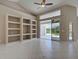 A spacious living room with tile floors, built-in shelves, and a sliding glass door at 1136 Deardon Dr, Venice, FL 34292