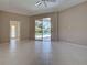 This main bedroom features light tile flooring, ceiling fan, and sliding glass doors to view of the backyard pool at 1136 Deardon Dr, Venice, FL 34292