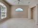 This is the main bedroom featuring neutral walls, tile flooring, a ceiling fan, and an open closet at 1136 Deardon Dr, Venice, FL 34292