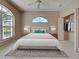 Well-lit main bedroom featuring a king bed, neutral walls, a ceiling fan, and a walk-in closet at 1136 Deardon Dr, Venice, FL 34292