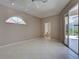 This main bedroom features light tile flooring, ceiling fan, arch window, and sliding glass doors to outdoor space at 1136 Deardon Dr, Venice, FL 34292