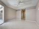 This main bedroom features light tile flooring, ceiling fan and sliding glass doors to outdoor living space at 1136 Deardon Dr, Venice, FL 34292
