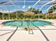 Sparkling screened-in pool area with fountain feature and surrounding greenery, ideal for relaxation and enjoyment at 1136 Deardon Dr, Venice, FL 34292