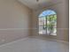 A simple room featuring tile floors, light-colored walls, and an arched window at 1136 Deardon Dr, Venice, FL 34292