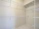 Spacious walk-in closet with ample storage including wrap around, floor-to-ceiling shelving and tile flooring at 1136 Deardon Dr, Venice, FL 34292