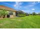Spacious backyard with lush green grass, a screened-in lanai, and well-maintained landscaping at 11739 Okaloosa Dr, Venice, FL 34293