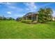 Well-manicured backyard with lush grass and a partial view of the screened-in patio at 11739 Okaloosa Dr, Venice, FL 34293