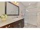 Modern bathroom featuring a glass-enclosed shower, dark wood vanity, and neutral color palette at 11739 Okaloosa Dr, Venice, FL 34293