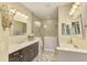 Bright bathroom with dual vanities, a glass-enclosed shower, and neutral finishes at 11739 Okaloosa Dr, Venice, FL 34293