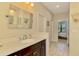 Bright bathroom featuring a single vanity, large mirror, and a glimpse into an adjacent bedroom at 11739 Okaloosa Dr, Venice, FL 34293
