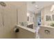 Shower with tiled walls, clear glass partition with doorway leading to the bathroom with dual sink vanity at 11739 Okaloosa Dr, Venice, FL 34293
