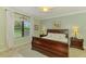 Serene bedroom featuring a large window, a wooden bed frame, and soft, cool-toned walls at 11739 Okaloosa Dr, Venice, FL 34293