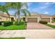 Welcoming home boasting lush landscaping, a brick driveway, and a two-car garage at 11739 Okaloosa Dr, Venice, FL 34293