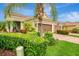 Inviting home featuring a brick driveway, lush landscaping, and a two-car garage at 11739 Okaloosa Dr, Venice, FL 34293