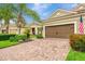 Exterior view of a home featuring a brick driveway and lush landscaping at 11739 Okaloosa Dr, Venice, FL 34293