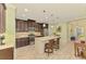 Bright kitchen featuring stainless appliances, an island with seating, and wood-look tile flooring, designed for modern living at 11739 Okaloosa Dr, Venice, FL 34293