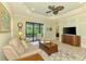 Bright living room with tile floors, sliding glass doors to the lanai, and elegant ceiling fan at 11739 Okaloosa Dr, Venice, FL 34293
