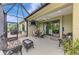 Covered patio with comfortable wicker seating, a ceiling fan, and an adjacent grilling area at 11739 Okaloosa Dr, Venice, FL 34293