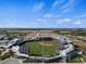 Stunning aerial view of a baseball field with manicured green grass, stadium seating, and clear blue skies at 11819 Tempest Harbor Loop, Venice, FL 34292