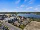 Aerial view of a neighborhood near a lake, showcasing modern architecture and meticulous landscaping under a blue sky at 11819 Tempest Harbor Loop, Venice, FL 34292