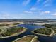 Scenic aerial view of a lake surrounded by lush greenery, walking trails, and interconnected waterways at 11819 Tempest Harbor Loop, Venice, FL 34292