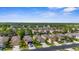 Aerial view showcases a residential community with lush landscaping, sidewalks, and various home styles nestled near a tranquil lake at 11819 Tempest Harbor Loop, Venice, FL 34292