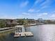 Aerial view of a lakefront dock with a slide, lounge chairs, and boat slips on a sunny day at 11819 Tempest Harbor Loop, Venice, FL 34292