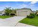 Well-maintained single-story home featuring a manicured lawn, established landscaping, and a spacious two-car garage at 11819 Tempest Harbor Loop, Venice, FL 34292