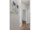 Hallway with wood floors and decorative artwork leading to bedrooms and bathrooms at 11819 Tempest Harbor Loop, Venice, FL 34292