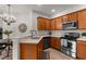 Well-appointed kitchen with stainless steel appliances, wood cabinetry, ample counter space, and an open layout at 11819 Tempest Harbor Loop, Venice, FL 34292