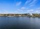 Picturesque lake view showcasing the waterfront with buildings, green spaces, and a clear blue sky at 11819 Tempest Harbor Loop, Venice, FL 34292
