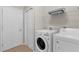 Bright laundry room featuring a modern washer and dryer, wire shelving, and a neutral color palette at 11819 Tempest Harbor Loop, Venice, FL 34292
