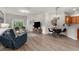 Spacious living room with dining area, chandelier, wood floors, and abundant natural light at 11819 Tempest Harbor Loop, Venice, FL 34292