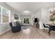 Open-concept living room with a chandelier, wood floors, ample seating, and access to the backyard at 11819 Tempest Harbor Loop, Venice, FL 34292