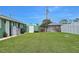 Spacious backyard featuring a green storage shed and well-maintained lawn, perfect for outdoor activities at 1198 Jamaica Rd, Venice, FL 34293
