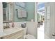 Bathroom with beadboard, a white vanity, and access to a screened porch at 1198 Jamaica Rd, Venice, FL 34293