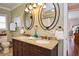 Well-lit bathroom featuring a double vanity, granite countertops, and decorative oval mirrors at 1198 Jamaica Rd, Venice, FL 34293