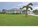 Charming single-story home surrounded by palm trees and a well-manicured lawn, showcasing curb appeal at 1198 Jamaica Rd, Venice, FL 34293